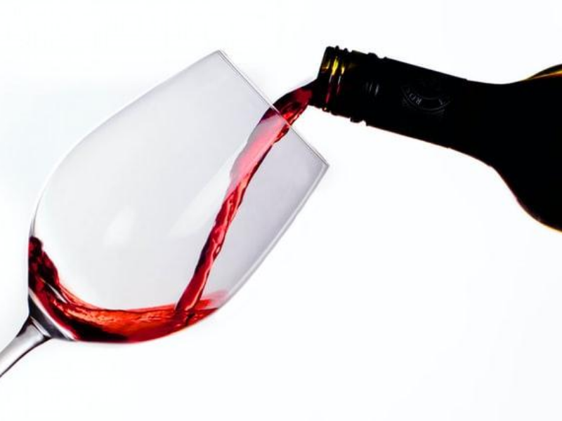 Nalévání červeného vína do sklenice