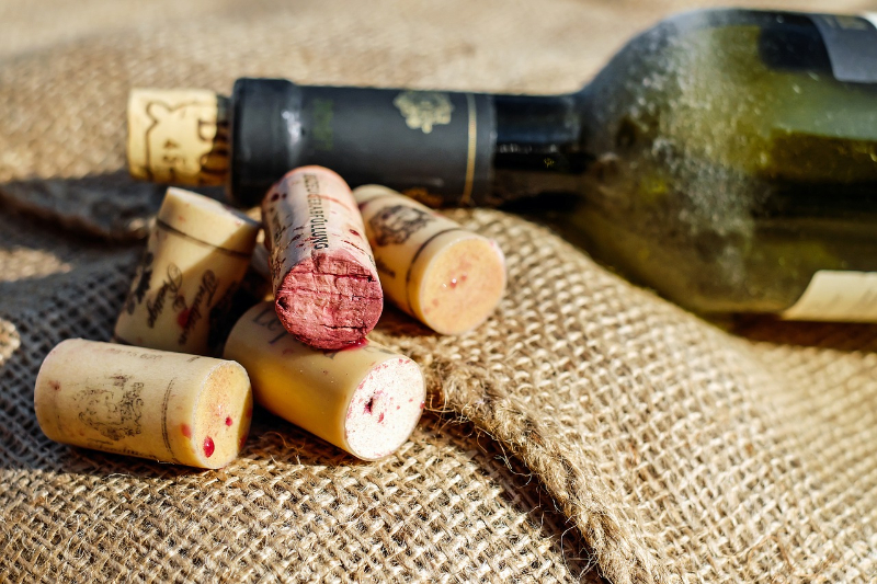 korky od vína ležící vedle láhve s vínem