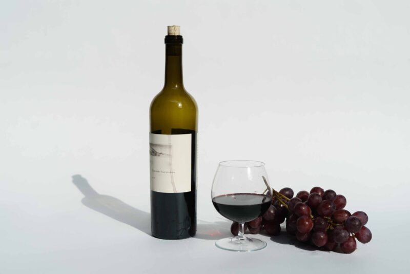 Butelka czerwonego wina z kieliszkiem z winem
